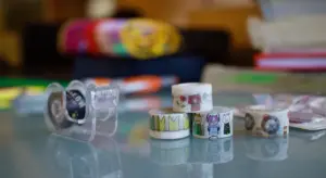 Close-up of assorted tapes on a glass surface, illustrating tape options for car paint protection.