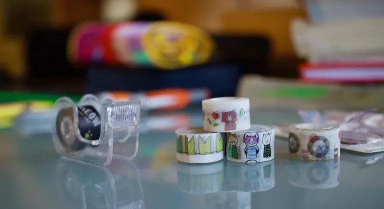 Close-up of assorted tapes on a glass surface, illustrating tape options for car paint protection.