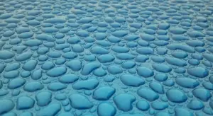 Close-up of a blue pebbled surface with rounded, smooth stones