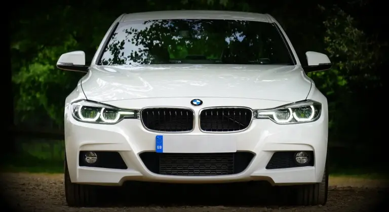 Front view of a white BMW sedan highlighting the front bumper.