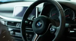 Close-up view of a BMW steering wheel and dashboard inside a modern car.