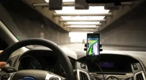 Interior of a car showing the dashboard and steering wheel with a smartphone mounted for navigation, illustrating a clean, well-maintained dashboard.