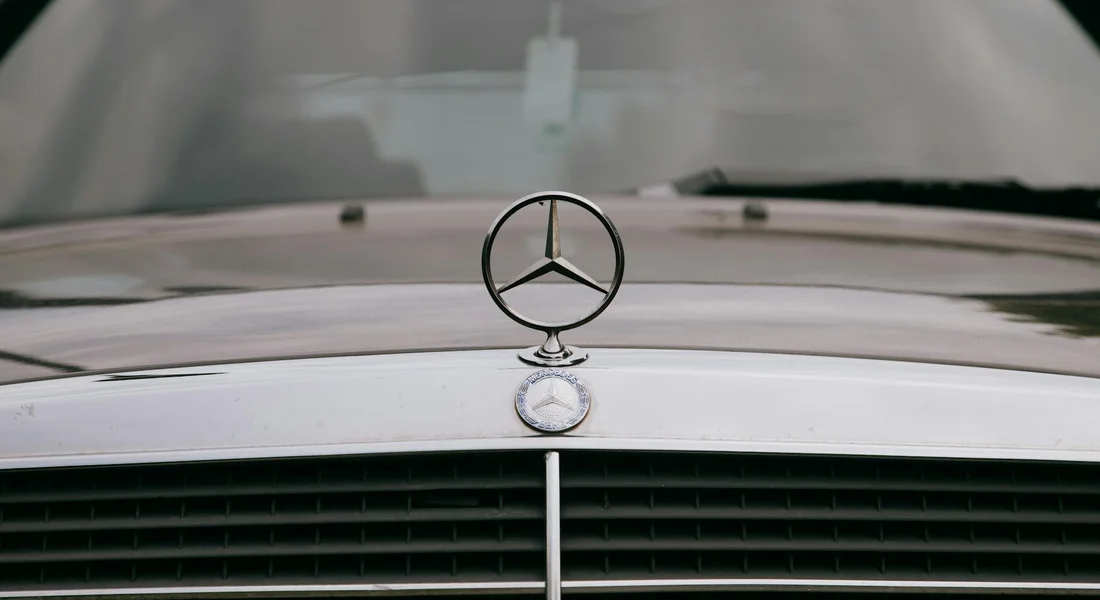 Close-up of a car hood with a Mercedes emblem and grille, illustrating the surface to be prepared for professional painting.