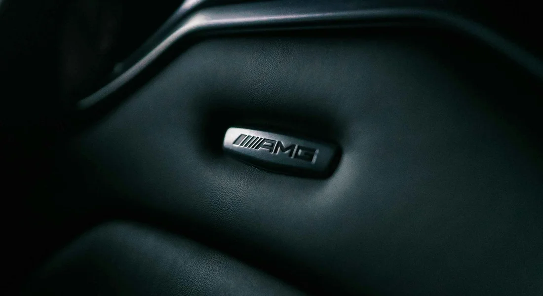 Close-up of a Mercedes-AMG badge on a dark car interior
