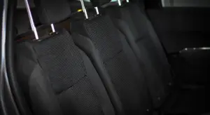 Backseat area of a car interior with black fabric seats and headrests.