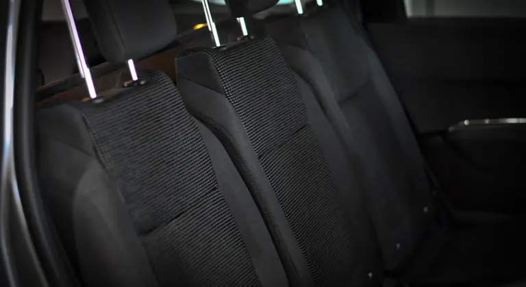 Backseat area of a car interior with black fabric seats and headrests.