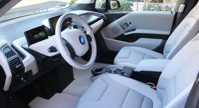 Interior of a modern car with light gray seats and dashboard, ready for spill-cleanup guidance.