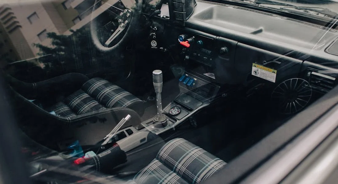 Interior of a car with plaid fabric seats and center console, ready for a hands-on cleaning demonstration.