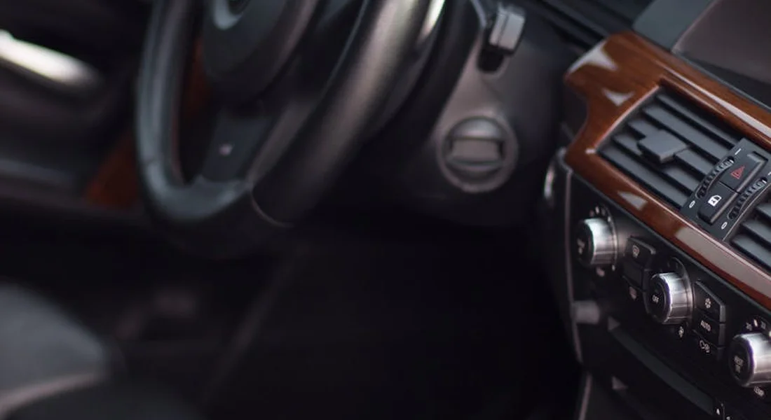 Close-up of a car interior showing the steering wheel and dashboard during a professional interior cleaning.