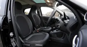 Interior view of a car showing the front seats, steering wheel, dashboard, and door panels.