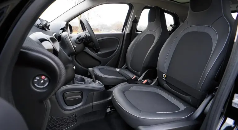 Front interior of a compact car showing two bucket seats and the dashboard