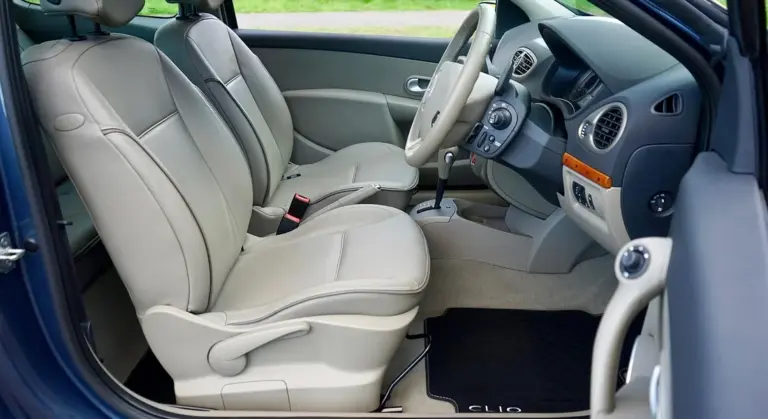 Inside a car showing beige leather seats and a clean console, illustrating leather upholstery.