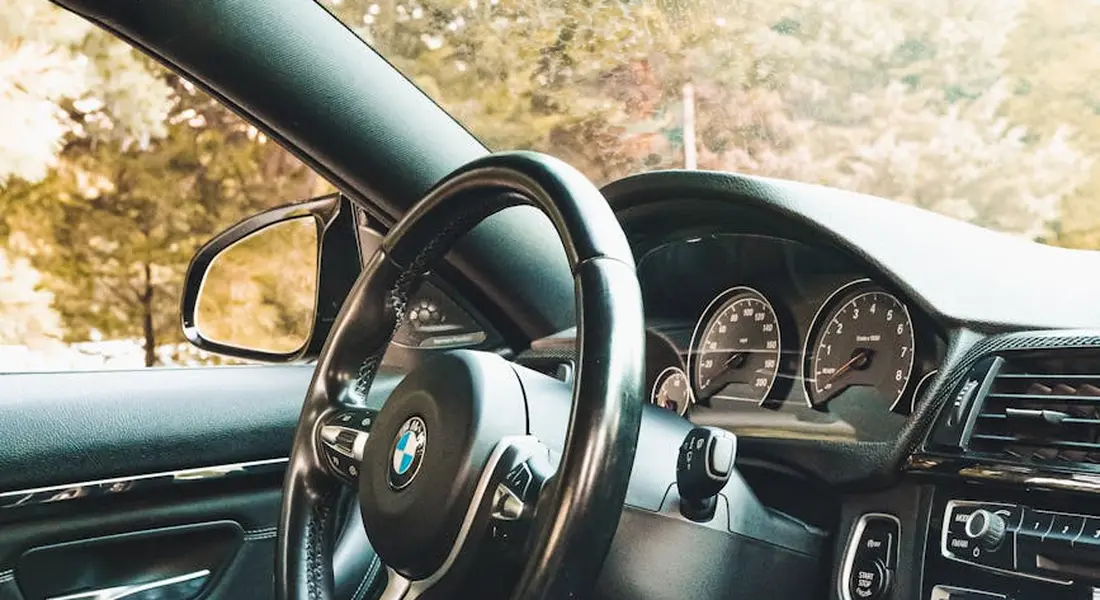 Interior of a car showing the steering wheel, dashboard, and window areas to illustrate surfaces discussed in window cleaning troubleshooting.