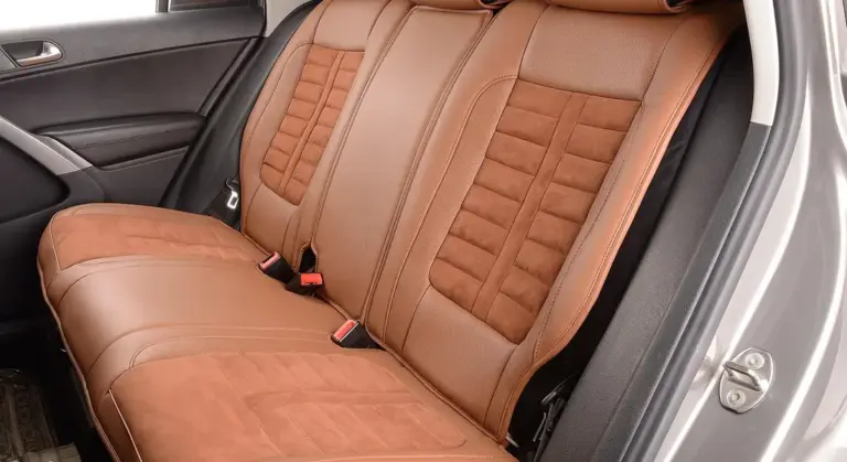 Back seat area of a car with brown leather upholstery.