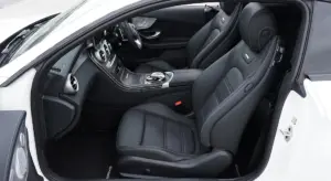 White car interior featuring black leather seats and a center console.
