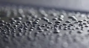Close-up of water droplets beading on a glossy car paint surface.