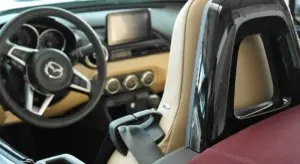 Interior of a car showing the steering wheel, dashboard, and seats, illustrating the detailing work on the vehicle's cabin.