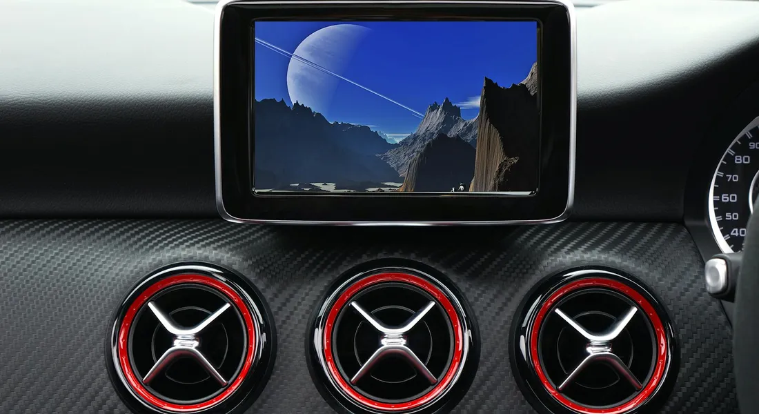 Car interior dashboard featuring three circular red-ringed air vents and a center display screen.