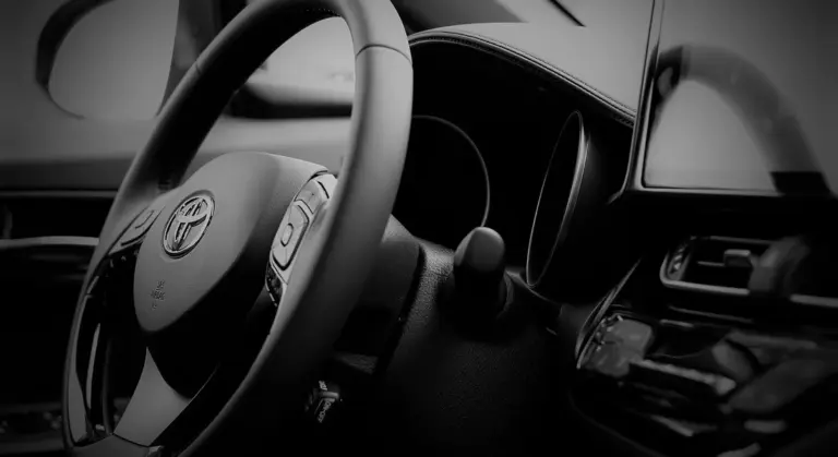 Close-up of a car's steering wheel and interior dashboard.