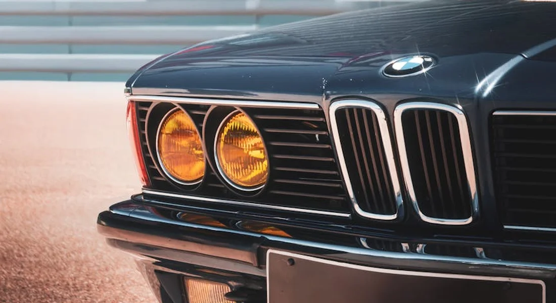 Close-up of a classic BMW front end featuring dual round headlights and distinctive kidney grilles.