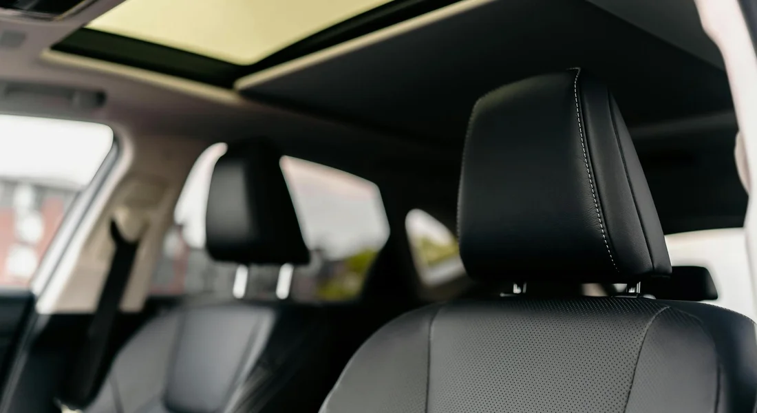 Close-up view of fabric car seats with headrests inside a car, illustrating the area where spills are cleaned.