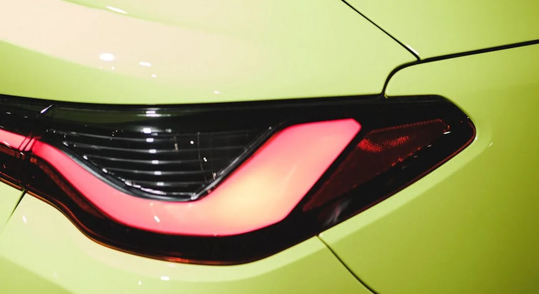 Close-up of a lime-green car with a red taillight