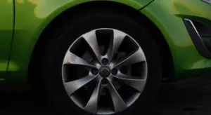 Close-up of a bright green car wheel with a silver alloy rim