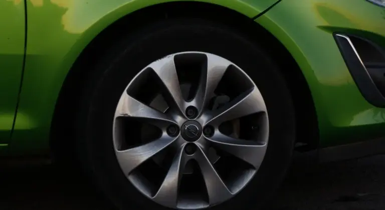 Close-up of a bright green car wheel with a silver alloy rim
