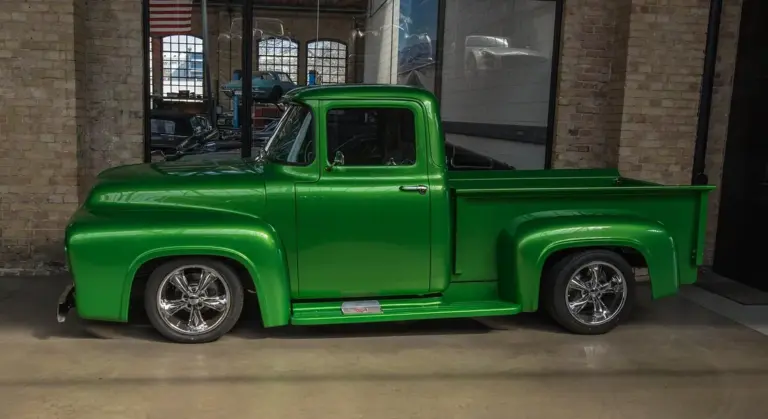 Bright green vintage pickup truck with chrome wheels in a showroom