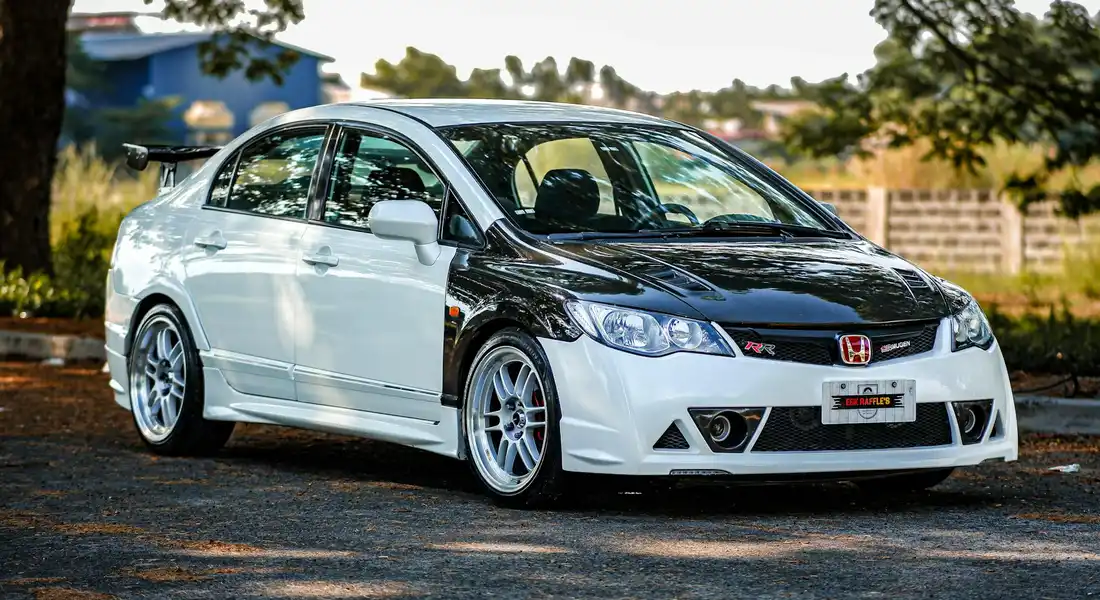 Two-tone Honda Civic with white body and black hood, featuring protective film and aftermarket wheels, parked outdoors
