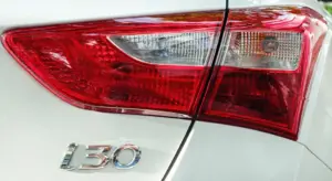 Close-up of a white Hyundai i30 rear, showing the red taillight and i30 badge.