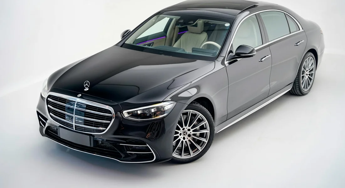 Glossy black Mercedes-Benz sedan in studio lighting with spotless, deep black paint.