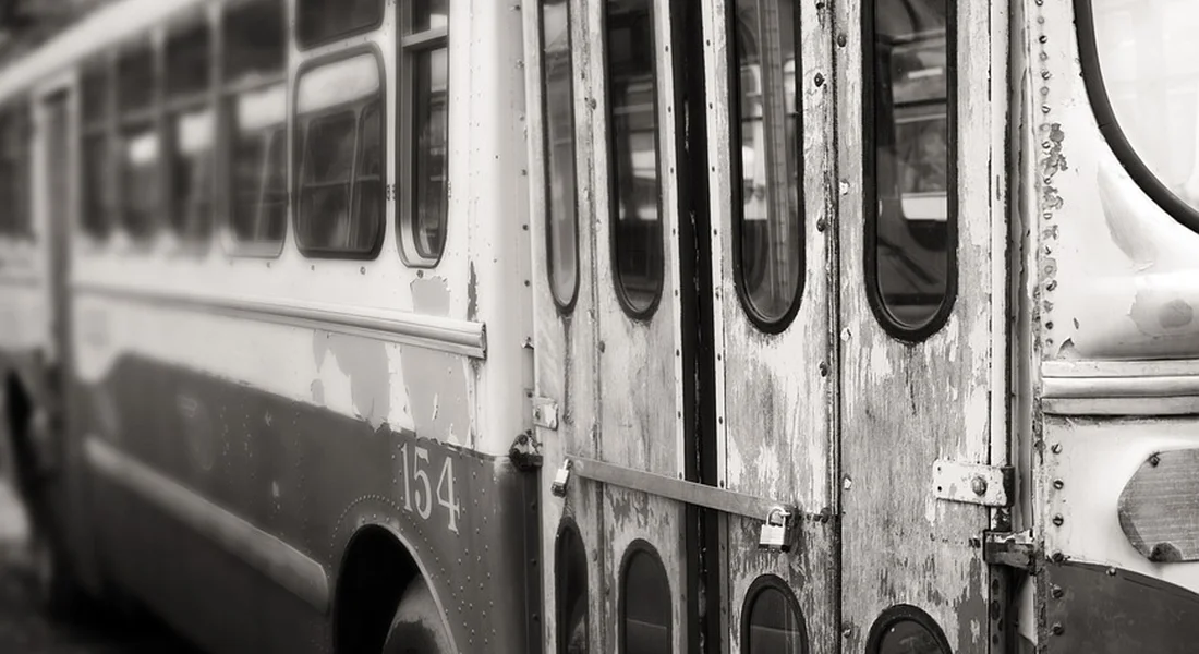 Black-and-white image of an old bus with weathered doors and peeling paint, illustrating oxidation and surface wear.
