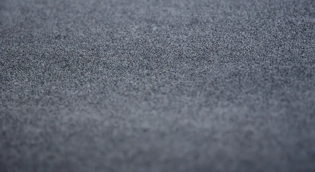 Close-up of sandpaper grit texture in blue-gray tones
