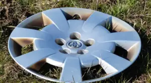 Close-up of a silver alloy wheel rim lying on grass