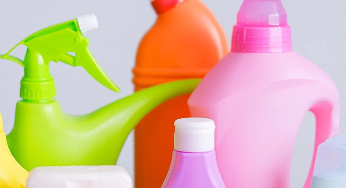 Assorted bright car-detailing spray bottles (green, pink, orange, purple) arranged on a light background.