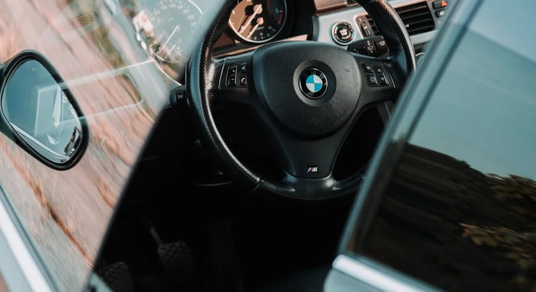 Car interior featuring the steering wheel and dashboard, illustrating the point of neutralizing odors inside the vehicle.