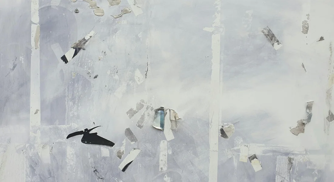 Close-up of tape fragments and adhesive residue on a pale car paint surface.