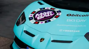 Close-up of a turquoise vinyl-wrapped sports car with promotional decals and logos.
