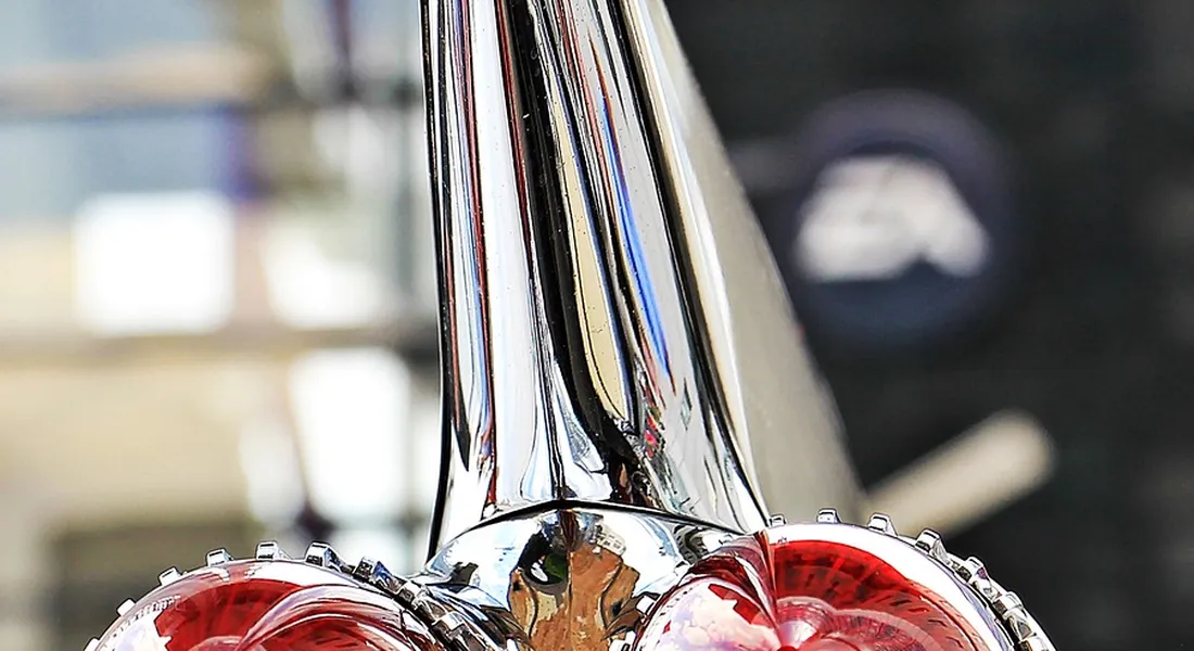 Close-up of a vintage chrome car tail light with reflections.