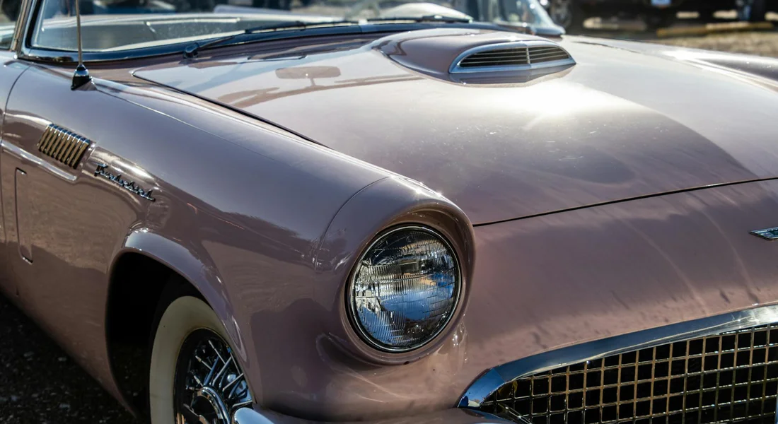 Close-up of a vintage purple car showing the front-left headlight and paint surface, illustrating a context for scratch repair guidance.